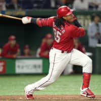 Carp slugger Xavier Batista belts a fourth-inning solo home run against the Giants on Friday night at Tokyo Dome. Batista hit two homers in Hiroshima's 8-3 victory over Yomiuri.