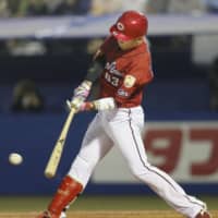 The Carp's Ryoma Nishikawa drives in a run in the fourth inning against the Swallows on Tuesday night at Jingu Stadium. Hiroshima beat Tokyo Yakult 8-7.