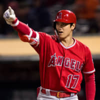 Angels designated hitter Shohei Ohtani signals for a runner to advance third base after Athletics catcher Josh Phegley (not pictured) loses possession of the ball at Oakland Coliseum.