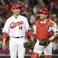 Carp starter Daichi Osera (left) and catcher Tsubasa Aizawa walk off the field after their win over the Dragons on Wednesday in Hiroshima.