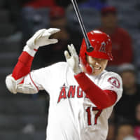 Los Angeles designated hitter Shohei Ohtani winces after being hit on the right hand by a pitch against Minnesota in the eighth inning on Monday night.