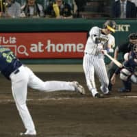 The Tigers' Kento Itohara hits a game-winning single in the ninth inning against the Swallows at Koshien Stadium on Thursday night. Hanshin won 1-0.
