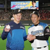 Hokkaido Nippon Ham rookie pitcher Kosei Yoshida poses with Fighters manager Hideki Kuriyama after earning the first win of his career on Wednesday at Sapporo Dome.