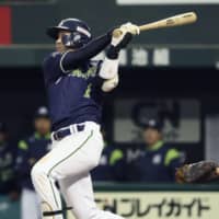 The Swallows' Tetsuto Yamada hits a ninth-inning sacrifice fly against the Lions at MetLife Dome on Saturday. Tokyo Yakult defeated Seibu 6-5.