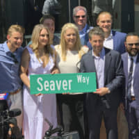 Anne Seaver (third from left) and her sister, Sarah Seaver, daughters of former New York Mets pitcher Tom Seaver, hold a street sign with team owner Jeff Wilpon ( third from right) outside Citi Field in New York on Thursday. Seaver is getting a statue outside the Mets' home, and the team is getting a new address.