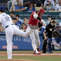 The Angels' Shohei Ohtani hits a pinch-hit RBI single against Dodgers pitcher Kenta Maeda during the second inning on Tuesday night at Dodger Stadium in Los Angeles.