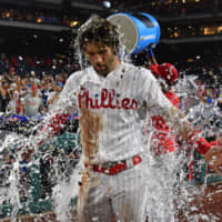 Bryce Harper is doused with water by Phillies teammate Jean Segura after the team's win over the Dodgers on Wednesday.