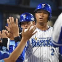 The BayStars' Jose Lopez is congratulated by teammates after his two-run homer against the Carp during the fourth inning on Wednesday at Yokohama Stadium. The BayStars won 3-1.
