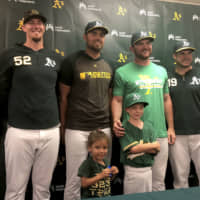 August Wold, center, stands with A’s players during a news conference on Saturday in Oakland.