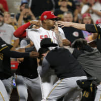 Reds reliever Amir Garrett (center) fights with Pirates players during the ninth inning on Tuesday in Cincinnati.
