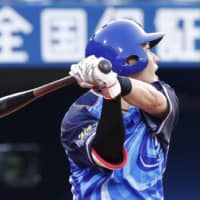 The BayStars' Kazuki Kamizato delivers a run-scoring hit in the second inning against the Swallows on Tuesday night at Yokohama Stadium. Yokohama beat Tokyo Yakult 6-2.