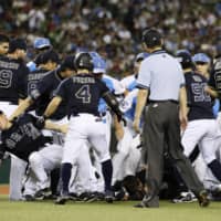The Seibu Lions and Orix Buffaloes push and shove one another after a benches-clearing incident in the fourth inning of Tuesday's game at MetLife Dome.