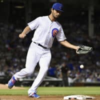 Cubs starting pitcher Yu Darvish commits an error while trying to catch the ball at first base against the Giants in the sixth inning on Wednesday at Wrigley Field.