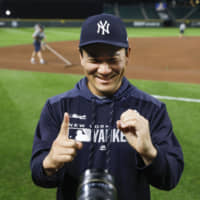 Yankees starter Masahiro Tanaka makes the number 10 with his hands after recording his 10th victory of the season on Tuesday in Seattle.