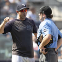 Yankees manager Aaron Boone (left) argues with home plate umpire Ben May during New York's game against Cleveland on Saturday afternoon at Yankee Stadium.