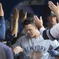 The Yankees' Gio Urshela celebrates with teammates after hitting his second two-run home run against the Blue Jays on Thursday night in Toronto.