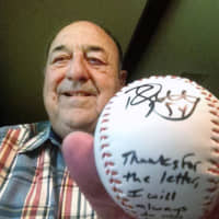 Former Hanshin Tigers pitcher Gene Bacque holds a ball signed by current Tigers pitcher Randy Messenger in a photo taken in August of 2014.