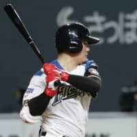 Fighters first baseman Kotaro Kiyomiya hits a bases-loaded single in the eighth inning against the Hawks on Sunday at Sapporo Dome.
