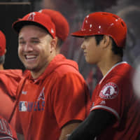 Angels outfielder Mike Trout (left) laughs next to teammate Shohei Ohtani during the first inning of a game against the Indians on Sept. 10 in Anaheim, California.