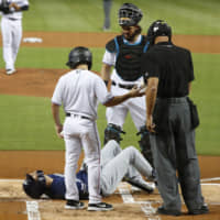 Brewers star Christian Yelich lies on the ground after an injury during an at-bat on Tuesday in Miami. Yelich broke his right kneecap on a foul ball and will miss the rest of the regular season.