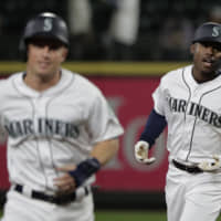 Seattle's Kyle Lewis (right) rounds the bases with teammate Kyle Seager after hitting a three-run homer against Cincinnati in the seventh inning on Wednesday night.