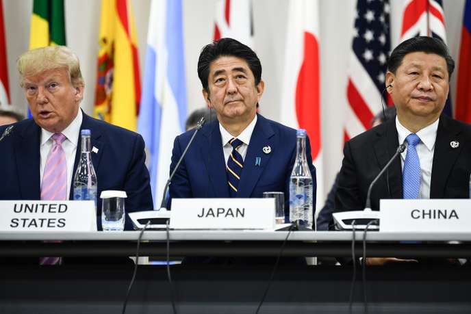 Le premier ministre japonais Shinzo Abe (au centre), entouré du président américain Donald Trump et du président chinois Xi Jinping, lors du G20 d’Osaka, le 28 juin.