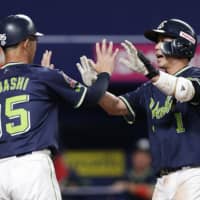 The Swallows' Tetsuto Yamada is congratulated by coach Katsuyuki Dobashi after belting a three-run homer in the 10th inning against the Dragons on Saturday at Nagoya Dome. Tokyo Yakult defeated Nagoya 5-2.
