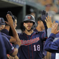 Twins catcher Mitch Garver is congratulated by teammates after hitting a home run against the Tigers in Detroit on Saturday. The ninth-inning blast was the Twins' 268th this season, setting a new MLB record.