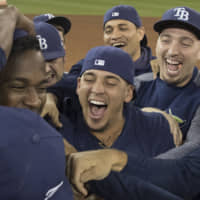 Rays players celebrate on the field after they defeated the Blue Jays to clinch an American League wild card berth on Friday night in Toronto.