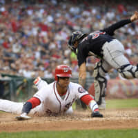 The Nationals' Juan Soto slides home past Indians catcher Eric Haase during the fourth inning on Saturday in Washington.