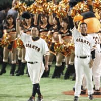 Retiring Giants star Shinnosuke Abe (left) tips his cap to the crowd as manager Tatsunori Hara looks on in the eighth inning of Friday's game against the BayStars at Tokyo Dome. Yomiuri defeated Yokohama 6-4 in the final regular-season game of Abe's illustrious career.