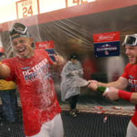 Cardinals outfielder Harrison Bader (right) sprays pitcher Jordan Hicks with beer as they celebrate winning the NL Central on Sunday in St. Louis.