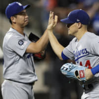 Dodgers reliever Kenta Maeda (left) celebrates his team's victory over the Mets with right fielder Enrique Hernandez on Sunday in New york.