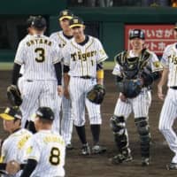 Tigers players celebrate their 3-0 win over the Dragons on Monday at Koshien Stadium. The result capped a six-game winning streak for Hanshin as it leapfrogged the Hiroshima Carp into third place and a spot in the Climax Series.