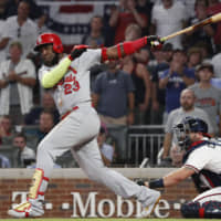 The Cardinals' Marcell Ozuna delivers a two-run double in the ninth inning against the Braves in Game 1 of the National League Division Series on Thursday in Atlanta.