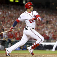 The Nationals’ Juan Soto hits a bases-loaded single against the Brewers in the eighth on Tuesday in Washington. Three runs scored on the play and Washington won the NL wild-card game.