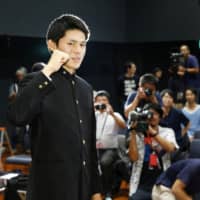 Pitcher Roki Sasaki poses for photographs during a news conference on Wednesday in Ofunato, Iwate Prefecture.
