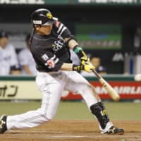 SoftBank's Nobuhiro Matsuda hits a two-run single in the top of the ninth inning against Seibu on Wednesday in Tokorozawa, Saitama Prefecture.