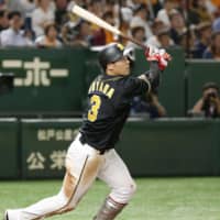 Hanshin's Yusuke Oyama hits a solo homer in the top of the ninth inning against Yomiuri on Friday night at Tokyo Dome. KYODO