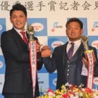 Central League MVP Hayato Sakamoto (left) of the Yomiuri Giants and Pacific League MVP Tomoya Mori of the Seibu Lions pose for photos at a Tokyo news conference after the NPB Awards on Tuesday.