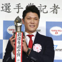 Yomiuri shortstop Hayato Sakamoto poses with his Central League MVP trophy on Tuesday during a news conference following NPB's award ceremony in Tokyo.
