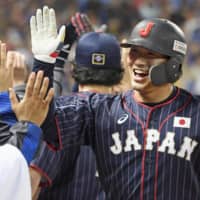 Seiya Suzuki greets teammates after hitting a two-run home run against Taiwan on Thursday in Taichung, Taiwan.