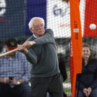 Democratic presidential candidate Sen. Bernie Sanders takes swings in the batting cage during a meeting with minor league baseball officials on Sunday in Burlington, Iowa.
