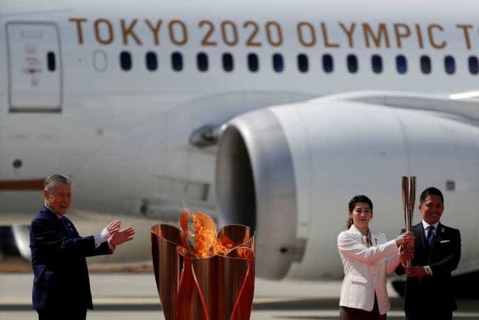 Les anciens champions olympiques Saori Yoshida et Tadahiro Nomura (à droite) ont allumé le chaudron olympique, aux cotés de Yoshiro Mori, président de Tokyo 2020, vendredi 20 mars sur le tarmac de l’aéroport de Matsushima.