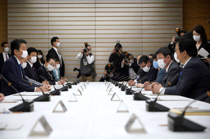 Le premier ministre japonais Shinzo Abe (à gauche) lors d’une réunion spéciale consacrée aux mesures prises pour contrer l’épidémie de coronavirus, le 6 avril.