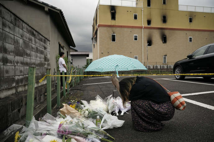 Une femme se recueille devant le studio KyoAni, à Kyoto, le lendemain de l’incendie, le 19 juillet 2019.