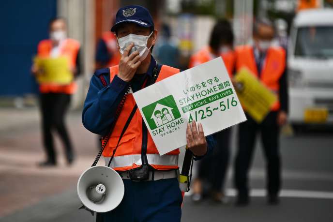 Des employés municipaux demandent aux gens de rester chez eux pendant l’épidémie de coronavirus, à Tokyo, le 4 mai 2020.