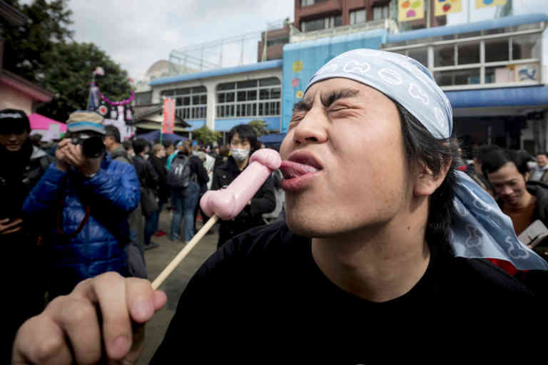 April 2, 2017 - Kawasaki, Kanagawa, Japan - Japan Visitors eat phallus candies during the Kanamara Festival at Kawasaki. The Kanamara Matsuri is held each first Sunday of April at the Kanayama shrine in Kawasaki, Japan. After the lighting of the sacred flame at the shrine, a huge pink phallus-shaped mikoshi altar is carried around the city during a procession. The penis, central theme of the event, is reflected in illustrations, candy, carved vegetables and decorations. Visitors can purchase small penis-shaped souvenirs and rub it on the sculpture for good luck. Originally the Kanamara Matsuri was centered around a local penis-venerating shrine once popular among prostitutes who wished to pray for protection from sexually transmitted diseases. Today, the festival has become something of a tourist attraction, with thousands of people from all over the world, and is used to raise money for HIV research.