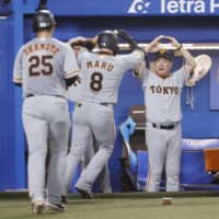 The Giants celebrate after a two-run home run by Yoshihiro Maru against the Swallows on Thursday at Jingu Stadium. | KYODO