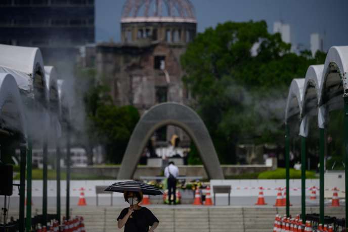 Une femme portant un masque traverse le parc commémoratif de la paix d’Hiroshima, le 5 août.